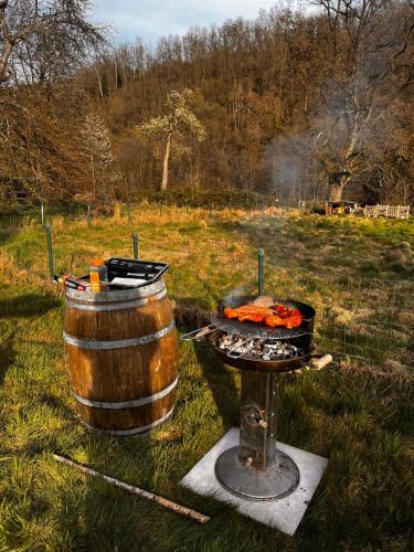 a bbq and a barrel and a grill at Charmant vakantiehuis aan de Ourthe in Maboge La Roche en Ardenne in La Roche-en-Ardenne