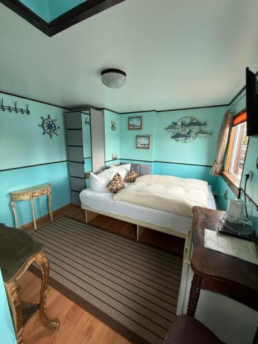 a bedroom with a bed in a room with blue walls at Schiffspension Luise in Potsdam