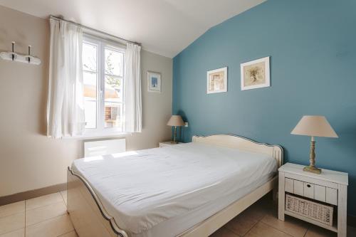 een slaapkamer met een wit bed en een blauwe muur bij Maison N°3 - Résidence Pingettes in Le Bois-Plage-en-Ré