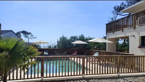 une clôture avec une piscine en face d'une maison dans l'établissement Villa Camelia Jacuzzi vue mer, à Lacanau