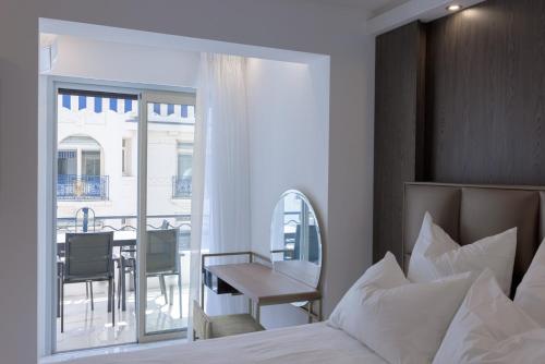 - une chambre avec un lit, une table et un balcon dans l'établissement Croisette Star - Bd Croisette, à Cannes