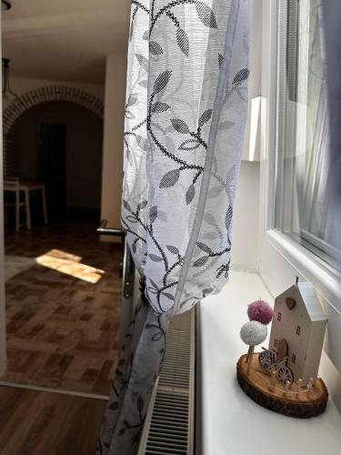 a table with a curtain and a toy house on it at Apartman Mitnica in Vukovar