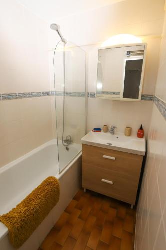 une salle de bain avec une baignoire, un lavabo et une douche dans l'établissement St cyprien appartement vue mer et piscine, à Saint-Cyprien
