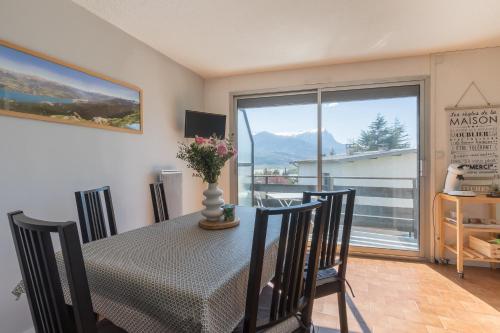 une salle à manger avec une table et des chaises et une fenêtre dans l'établissement Les 4 Soleils - Jolie vue montagnes, à Embrun