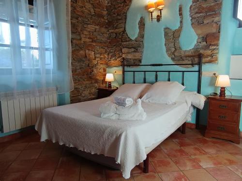 a bedroom with a bed with white sheets and pillows at Hotel y Apartamentos Penarronda Playa in Castropol