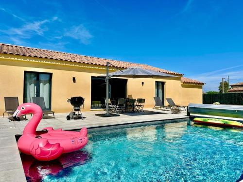 un flamingo gonflable rose dans une piscine dans l'établissement Villa Pinea avec piscine chauffée en Provence, au Muy