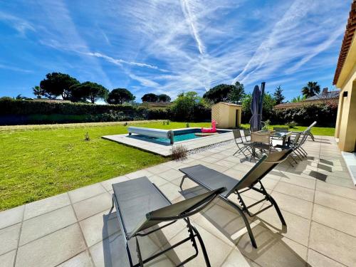 un patio avec des chaises, une table et un banc dans l'établissement Villa Pinea avec piscine chauffée en Provence, au Muy