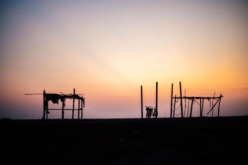 a silhouette of a building with the sunset in the background at Hill Village Phu Yen in Phú Hiệp (2)