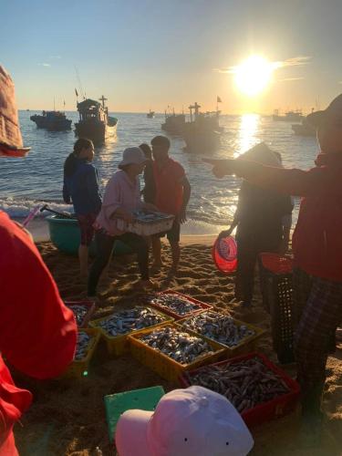 a group of people standing on a beach selling fish at Hill Village Phu Yen in Phú Hiệp (2)