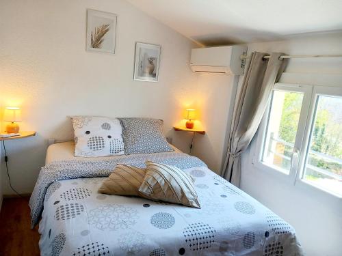 a bedroom with a bed and two lamps and a window at Maisonnette au calme in Saint-Vallier-de-Thiey