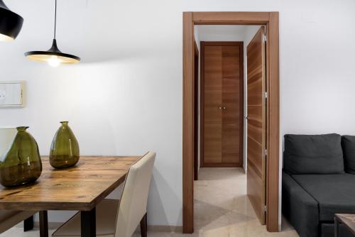 a dining room with a table and a couch at Suites Campo del Príncipe by Maxi Hoteles in Granada