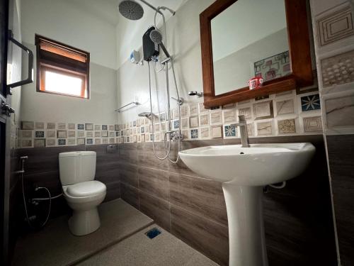 a bathroom with a sink and a toilet and a mirror at Pearl Queen in Talawakele