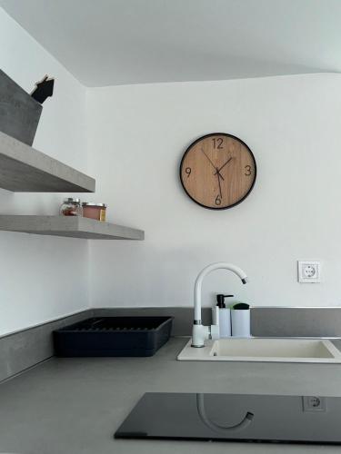 a clock on the wall above a kitchen sink at Adosado privado playa in San Antonio