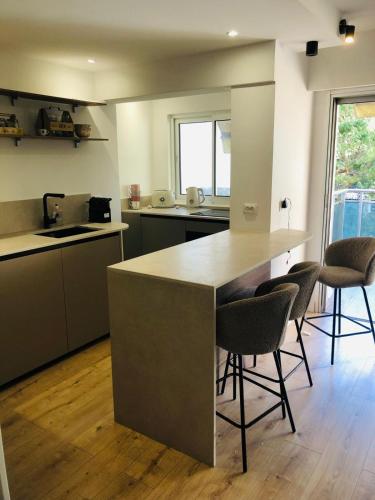 - une cuisine avec un comptoir et quelques chaises dans l'établissement Studio terrasse Croisette, à Cannes