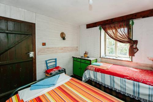 1 dormitorio con 2 camas, vestidor y ventana en Къща за Гости Марго, en Kosti