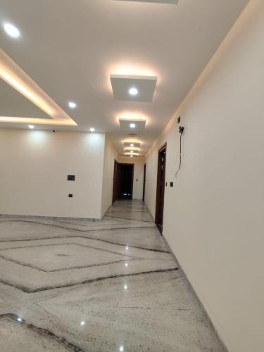 an empty room with white walls and a hallway at Sunrise vista Near expo center in Greater Noida