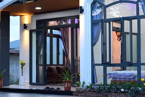 a house with a large glass door with a couch at Đông Lưu Homestay in Hoat