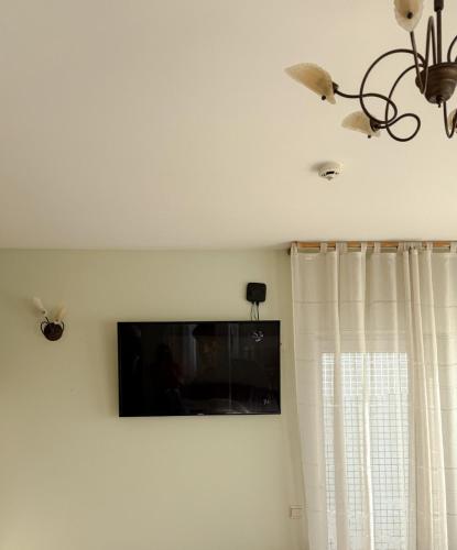 a flat screen tv on a wall with a window at Comfy stay at Hill of Clouds in Rāmava