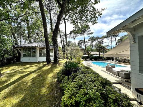 une maison avec une cour et une piscine dans l'établissement Pyla Magnifique maison avec piscine proche de la dune pleine de charme, à La Teste-de-Buch