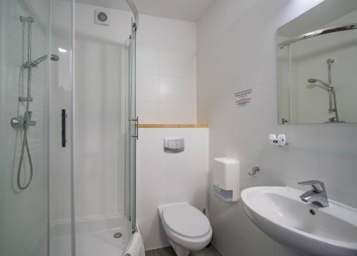 a bathroom with a toilet and a sink and a shower at Maximus Spa in Dziwnówek
