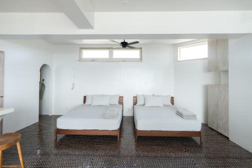 two beds in a room with white walls and windows at DESLIE - Vacation STAY 74346v in Sarahama