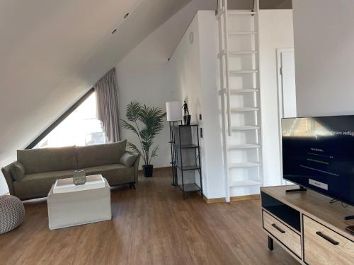 un salon avec un canapé et une télévision dans l'établissement Ferienwohnung Zwischenhoch, à Kranenburg