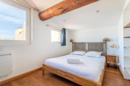 une chambre avec un lit et une fenêtre dans l'établissement L'appartement du Vieux-Port Marseille, à Marseille