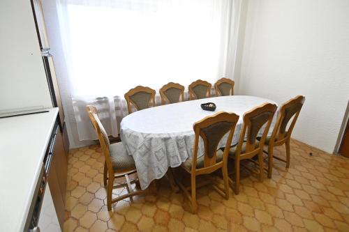 a dining room table with chairs and a white tablecloth at Vikend Kuća Živković in Despotovac