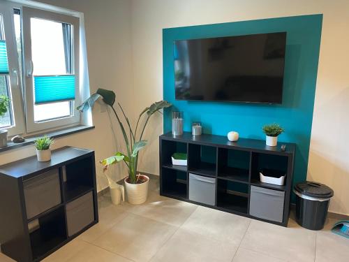 a black entertainment center with a flat screen tv on a wall at Großkoschen Wohnungen in Senftenberg