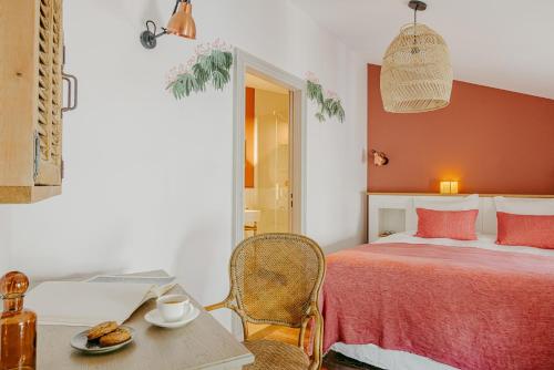 a bedroom with a bed and a table with a plate of food at Logis de la Cadène - Teritoria in Saint-Émilion