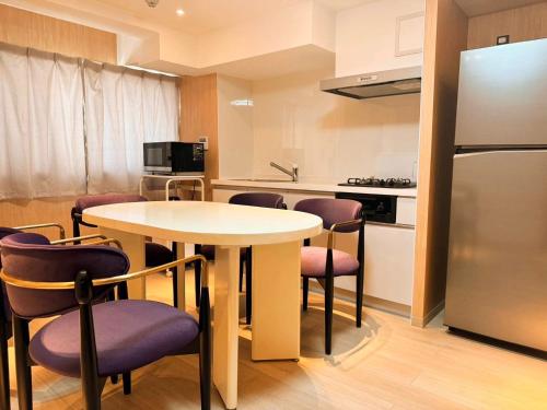 a kitchen with a table and chairs and a refrigerator at MKG Home・芝 in Tokyo