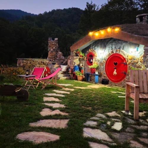 a house with a red wheel in the yard at Zemljane kućice Kreševo in Kreševo