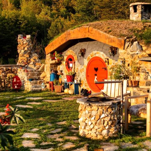 a stone house with a fire pit in a yard at Zemljane kućice Kreševo in Kreševo