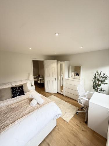 a white bedroom with a large bed and a desk at Luxury 3BDR apartment in King’s cross in London