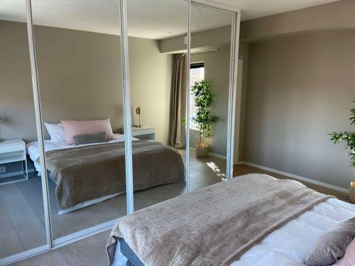 Un dormitorio con dos camas y un espejo. en Leilighet med høy standard og fantastisk havutsikt, en Kabelvåg