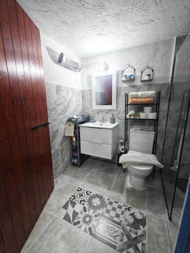a bathroom with a toilet and a sink and a door at Mamas Summer House in Larnaca