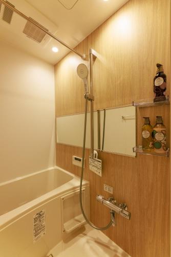 a shower in a bathroom with a tub at MKG Home・芝 in Tokyo
