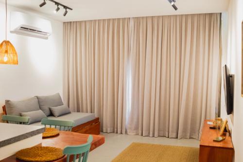 a living room with a couch and a table at Villa Naluri - Casa Yodo - Apartamento 1 quarto em Japaratinga in Japaratinga