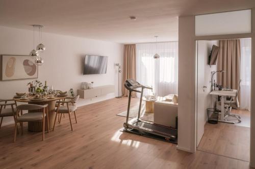 a living room with a table and a dining room at Apartment HomeBase Modernes 4-Sterne Apartment mit Tiefgarage im Zentrum in Oberkochen