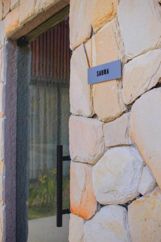 a sign on the side of a stone wall at Villa Naluri - Casa Yodo - Apartamento 1 quarto em Japaratinga in Japaratinga