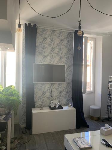 un salon avec une télévision sur un mur dans l'établissement Cosy Cottage by Alice Marseille Centre & Plage, à Marseille