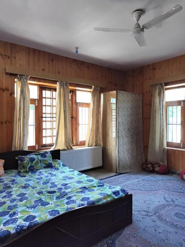 a bedroom with a bed in a room with windows at The Bilt farmhouse in Srinagar