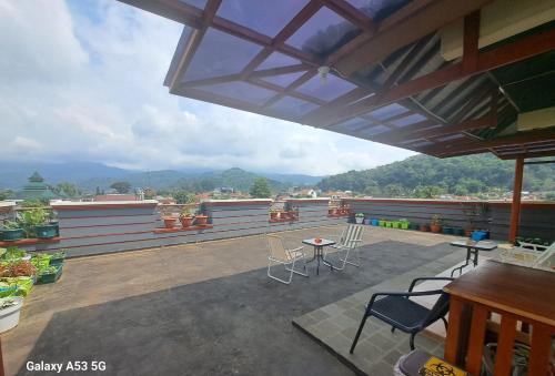 a patio with chairs and a table on a roof at Cipada Guesthouse syariah in Sumedang