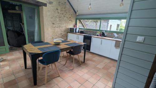 une cuisine avec une table et des chaises dans une cuisine dans l'établissement Environnement exceptionnel, à Coulans-sur-Gée