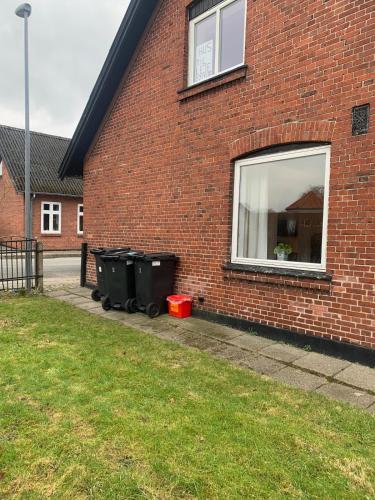 a brick building with trash cans next to a window at Townhouse centrally located close to Jesperhus in Nykøbing Mors