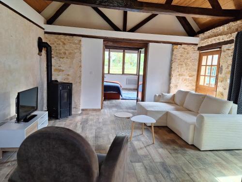 un salon avec un canapé blanc et une télévision dans l'établissement Environnement exceptionnel, à Coulans-sur-Gée