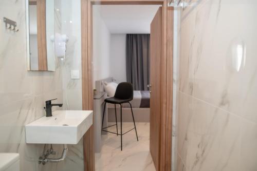 a bathroom with a sink and a shower and a chair at Filoxenia cozynest in Marmari