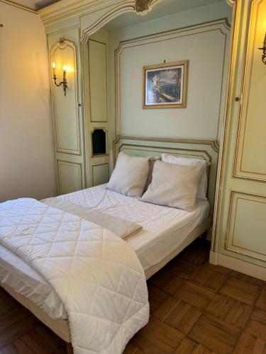 une chambre avec un lit avec des draps blancs et des oreillers dans l'établissement La Casita, à 10 minutes de la plage, à Soustons