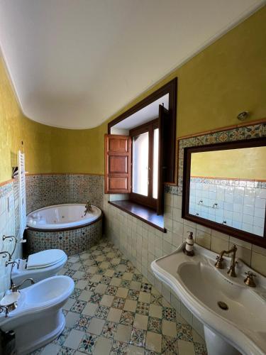 a bathroom with two sinks and a tub and two toilets at Agriturismo Tenute Spartà in Randazzo