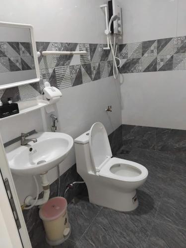 a bathroom with a toilet and a sink at MUINE MOMO Homestay in Ấp Khánh Phước (1)